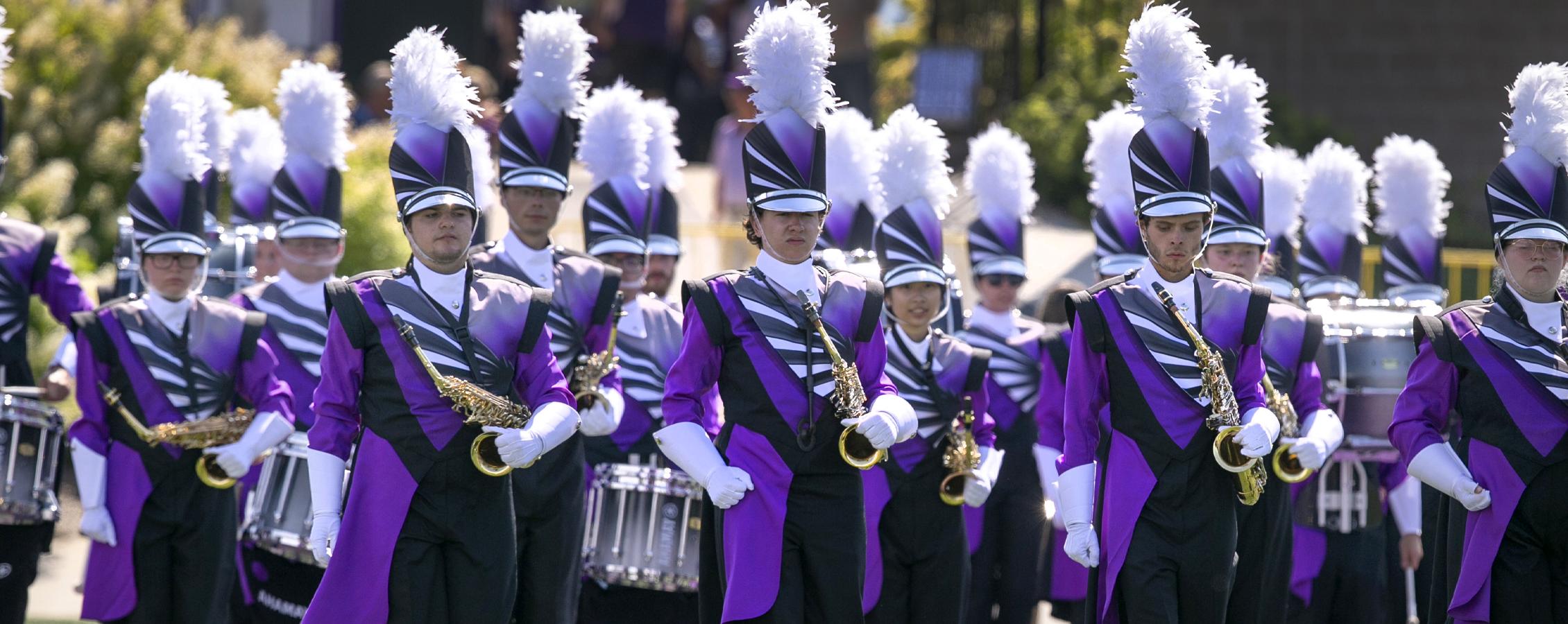 The Marching Band stands at attention in full uniform.